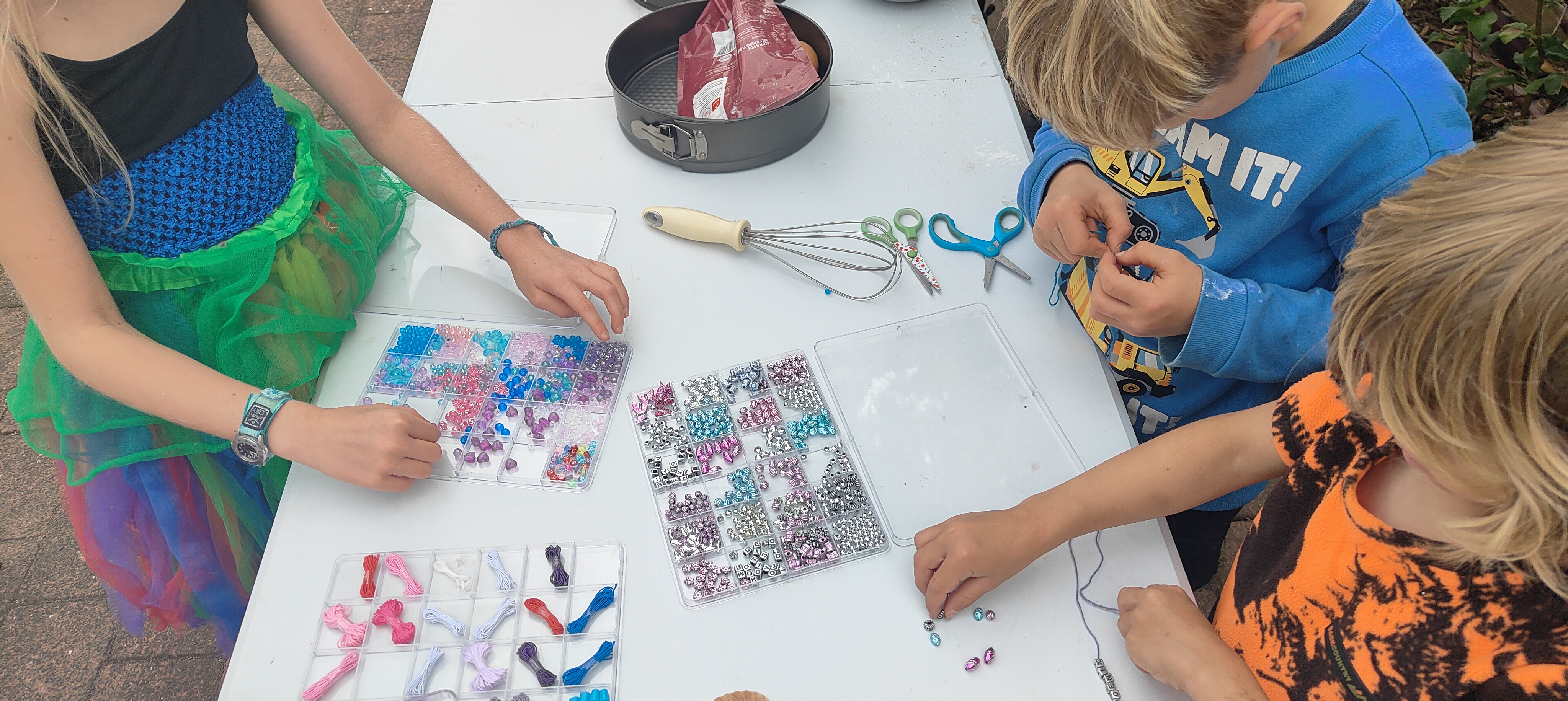 Children making jewellery with beads together