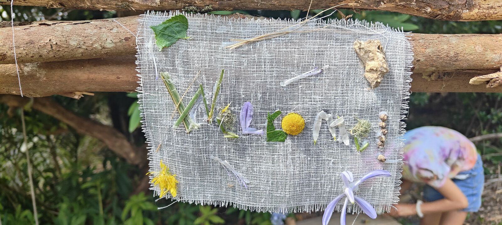 Hand-crafted welcome sign at The Bush Base made from natural materials